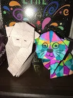 Photographie d'origami de chat et de singe sur une étagère.