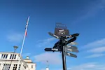 Photographie des panneaux indiquant les distances et less directions des grandes villes du monde par rapport à Bergen.