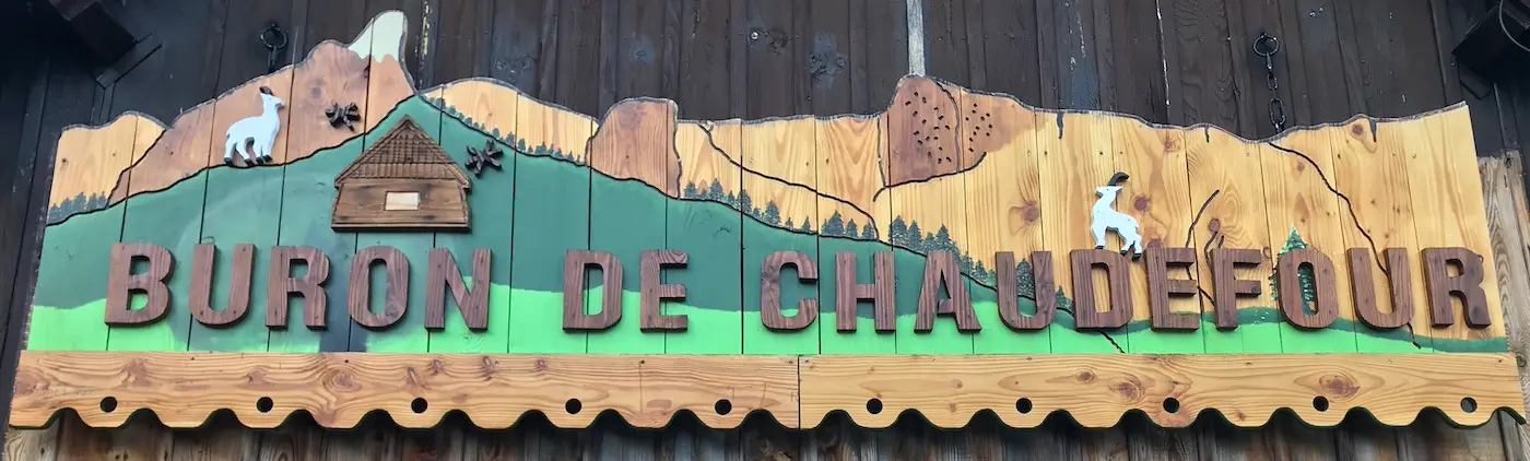 Panneau en bois sur le façade du buron à l’entrée de la vallée.