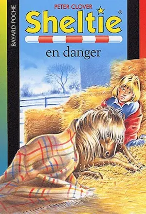 Couverture du livre pour enfants Sheltie en danger représentant le dessin d'une enfant et d'un poney couchés sous une couverture dans la paille.