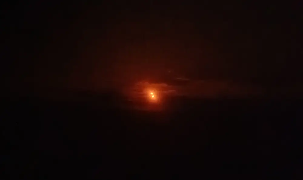 Photo de l'éclipse quasiment au climax, on voit le contour rougeoyant du soleil au milieu d'une image noire.