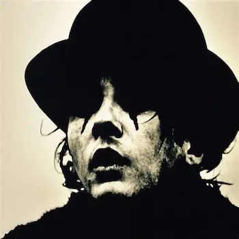 Pochette de l’album représentant le portrait de Saez, maquillé, avec un chapeau.